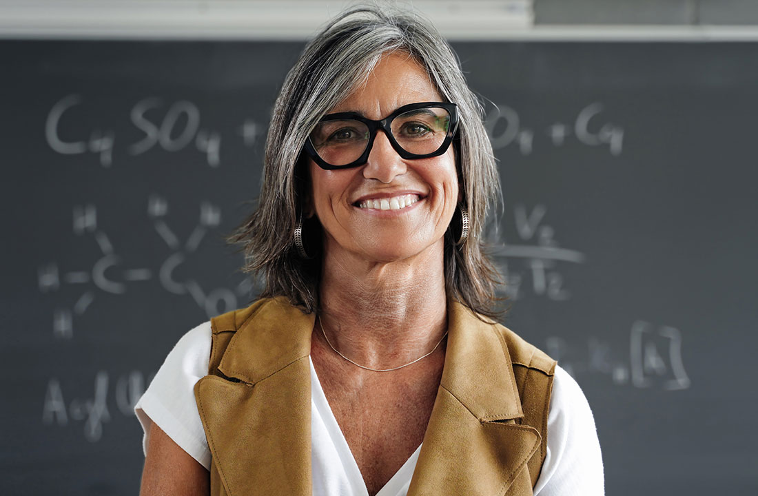 Female teacher in front of chalkboard.